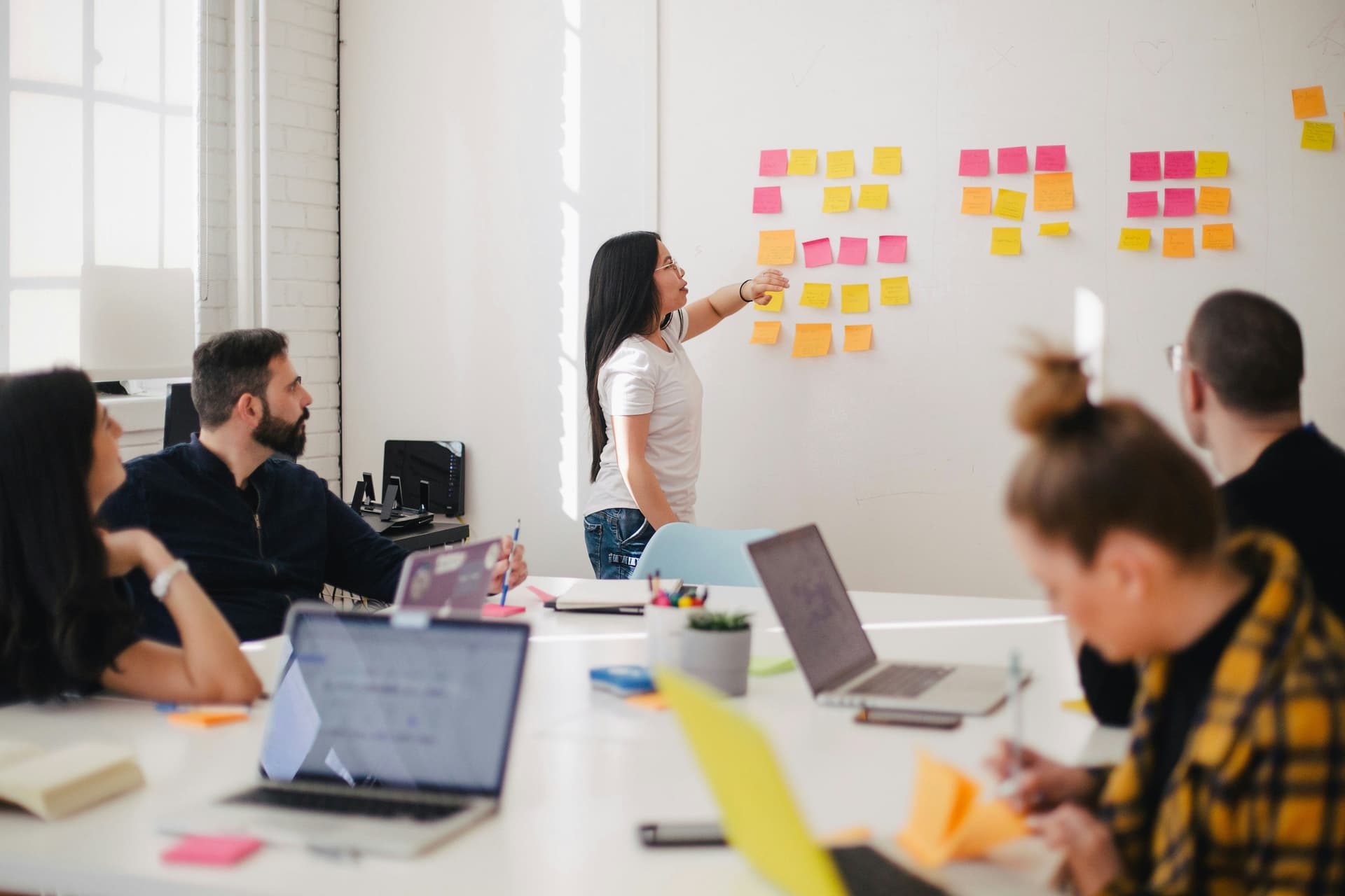 Marketing team planning a go-to-market launch strategy with sticky notes on a wall